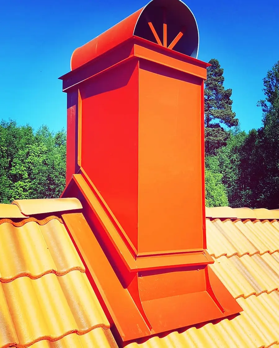 Rött skorstensbeslag på tegeltak utfört av BRA Bygg & Tak